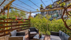A covered outdoor seating area with wicker furniture and a pergola structure.