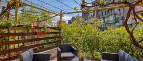 A covered outdoor seating area with wicker furniture and a pergola structure.