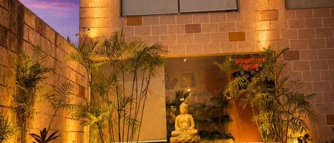 A building with a brick facade, a Buddha statue, and a sign that reads 'COVENIERS SHOP.'