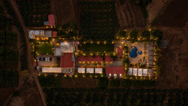 An aerial view of a resort with multiple buildings, a swimming pool, and a parking area. - LION PARK HOTEL AND RESORT (Maliya)