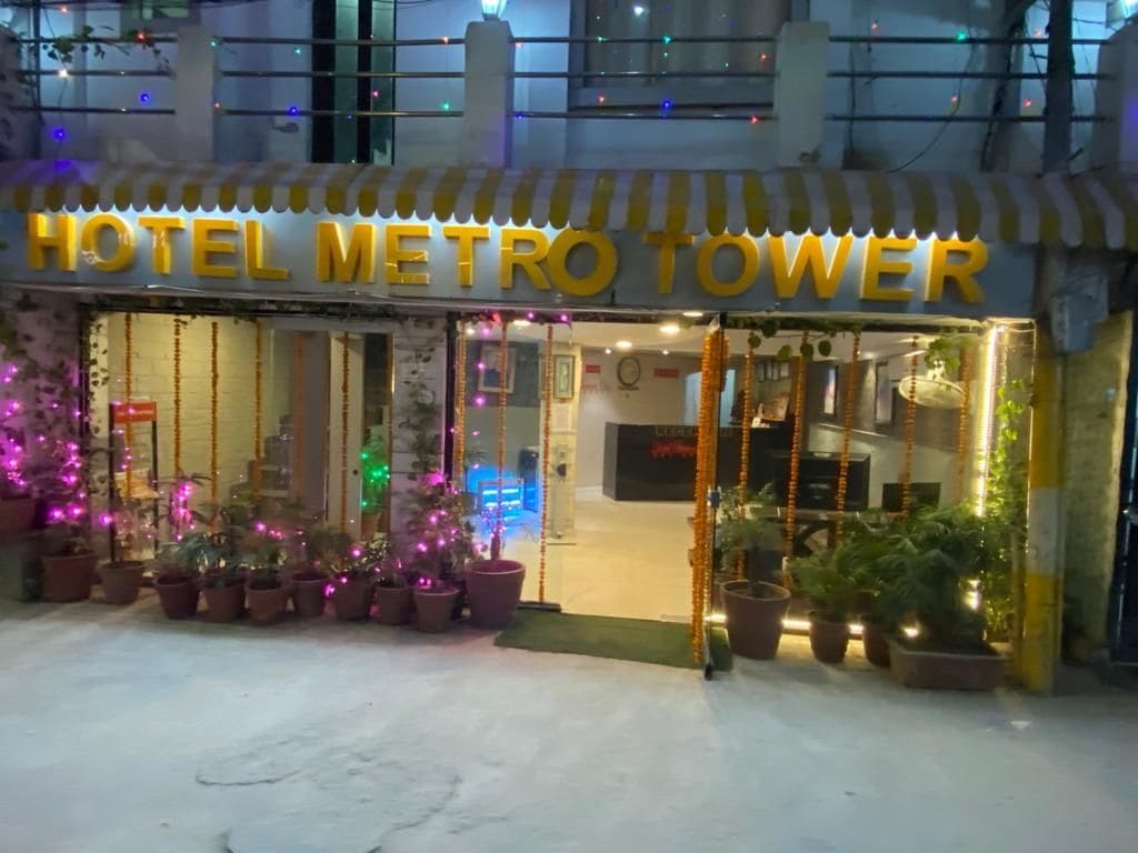 Een hotelentree met een bord waarop 'HOTEL METRO TOWER' staat.