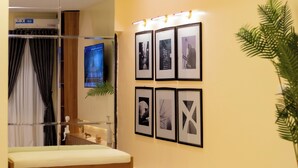 A modern bathroom with a glass shower enclosure, a bench, and framed pictures on the wall. - 1-Bedroom Apartment in Lekki off Admiralty (Lekki Phase 1)