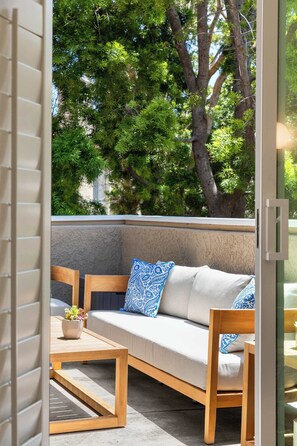 A modern outdoor seating area with a sofa and chairs, a small table, and a potted plant. - Tranquil Coastal Escape with Pool & Spa (San Diego)