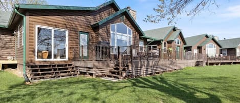 Experience the charm of a rustic retreat with a cozy porch and large windows.
