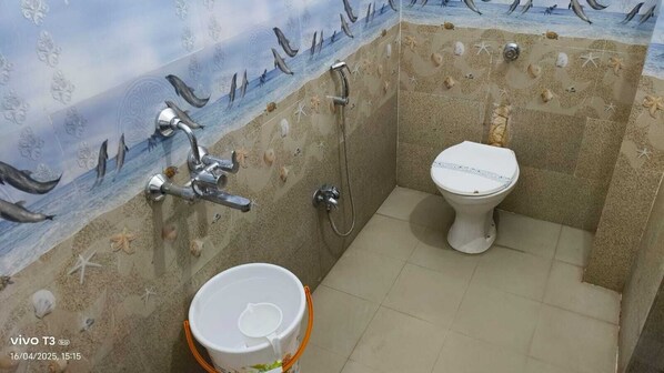 Un baño con ducha, inodoro y lavamanos, decorado con un mural de playa.