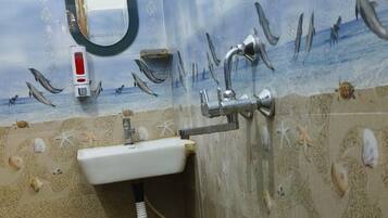 Un baño con un mural temático marino, un lavamanos y un secador de manos.