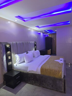 A modern bedroom with a large bed, a bedside table, and a wardrobe. - Preserve Hotel Ilupeju (Lagos)