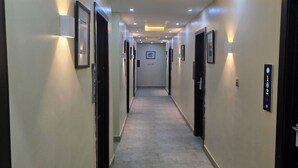 A hotel hallway with a tiled floor, recessed lighting, and doors on both sides. - Preserve Hotel Ilupeju (Lagos)