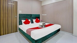 Une chambre d’hôtel avec un grand lit, une porte en bois et un ventilateur de plafond.