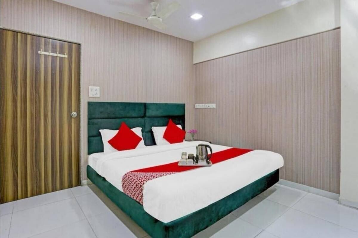 Une chambre d’hôtel avec un grand lit, une porte en bois et un ventilateur de plafond.