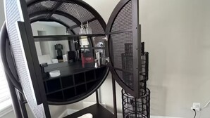 A corner of a room with a black TV stand, a white shelf, and a black speaker. - Spacious and Quiet 4 Bedroom House 5min Drive to DC (Arlington)
