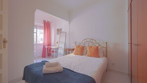 A bedroom with a bed, a desk, and a chair. - Alameda Typical by Homing (Lisbon)