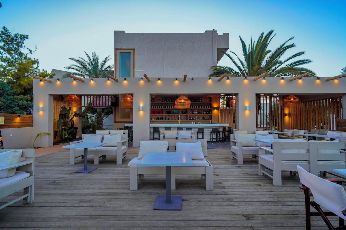 An outdoor seating area with white furniture and a wooden deck.