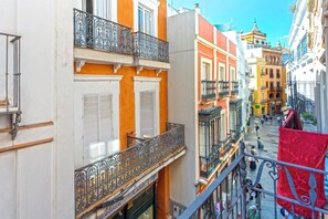Un carrer estret amb edificis que tenen balcons i persianes.