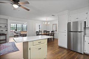 Enjoy meals in the kitchen with a central island, dining area, and stainless steel refrigerator.