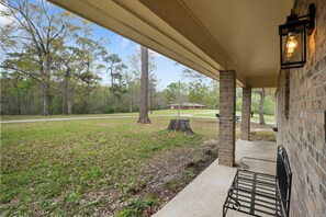 Relax under the pergola, surrounded by lush greenery and a serene lawn.