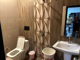Un baño con inodoro, bidé, lavabo y espejo.