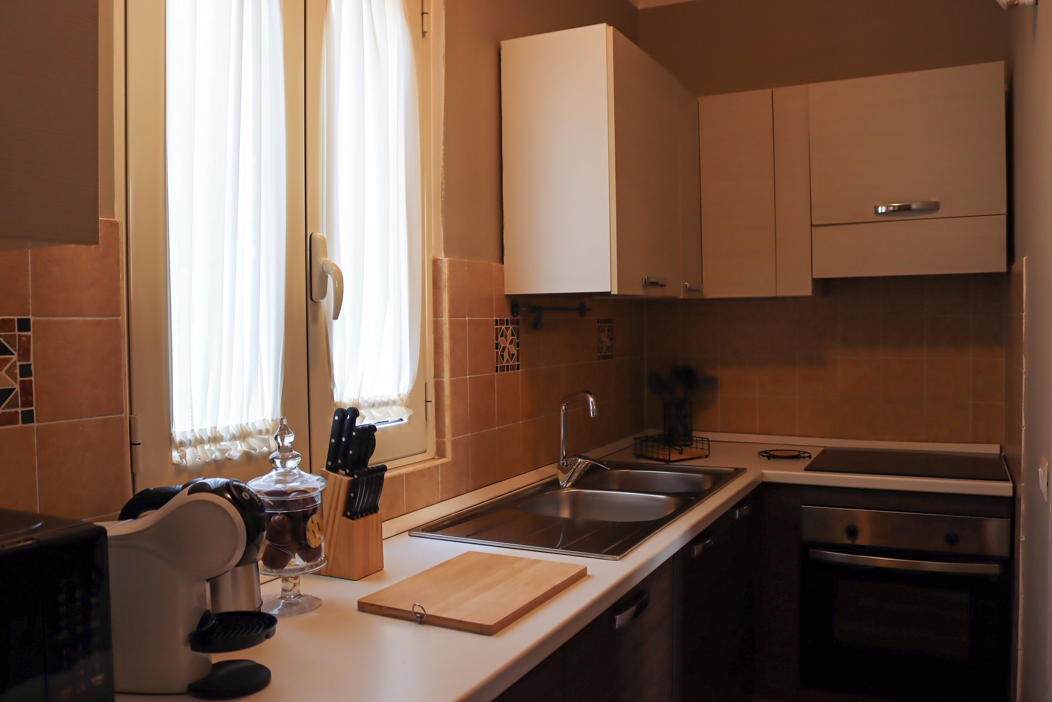 Una cocina moderna con un lavabo, estufa y armarios.