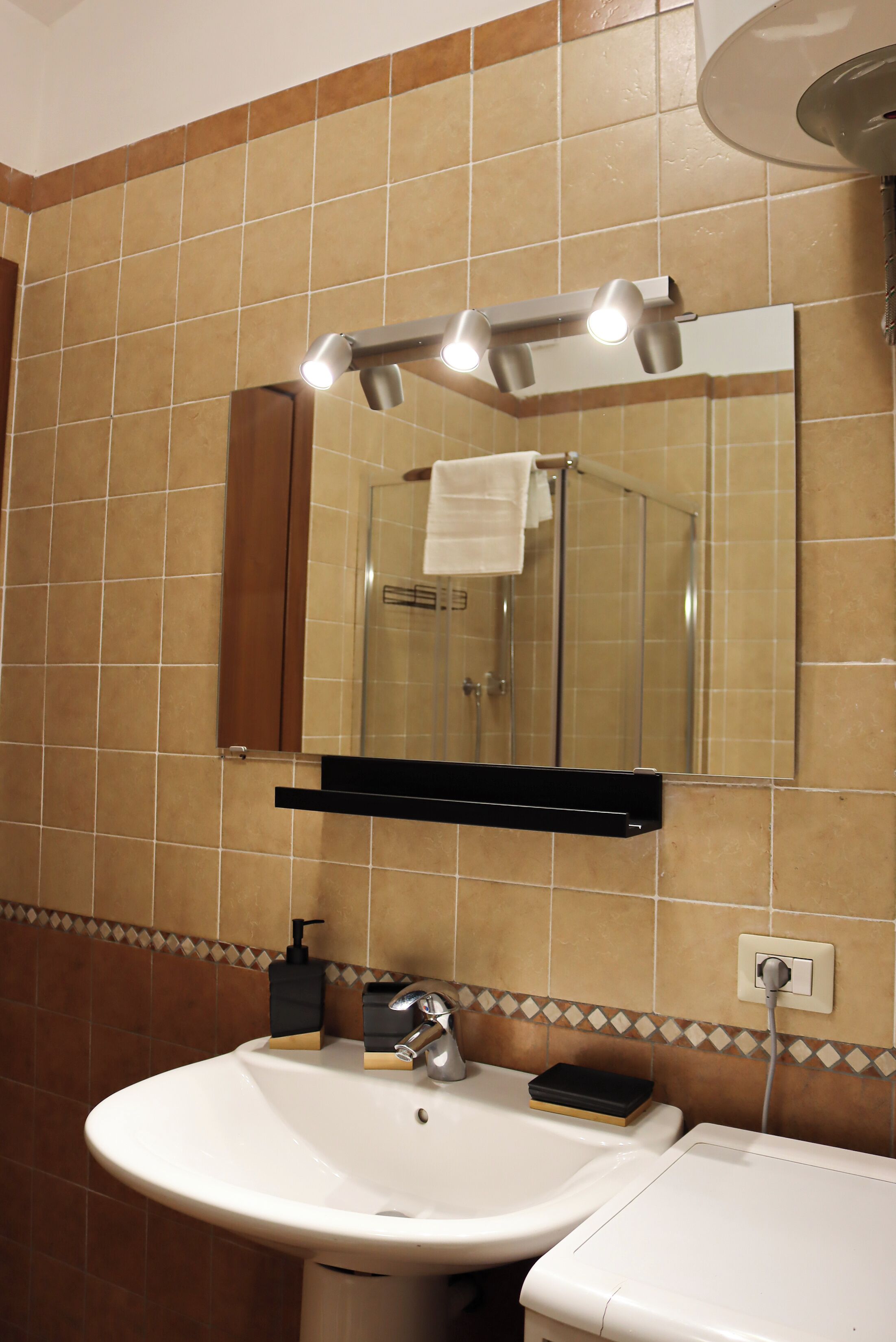 Une salle de bain avec un lavabo, un miroir et une douche.