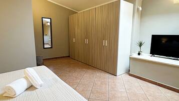 Une chambre d’hôtel avec un lit, une télévision, une armoire et une lucarne.