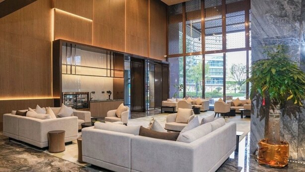 A spacious lobby with a large sofa, a coffee table, and a potted plant. - KEEJOY HOTEL (Fuzhou)
