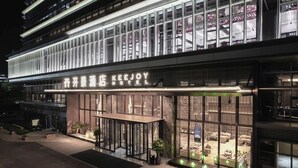 The exterior of the KeeJoy Hotel with a modern facade, large windows, and a well-lit entrance area. - KEEJOY HOTEL (Fuzhou)