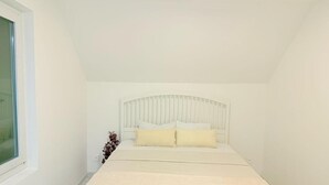 A bedroom with a bed, a window, and a white headboard. - Luxrem 5 Apartments Skyline (Biel)