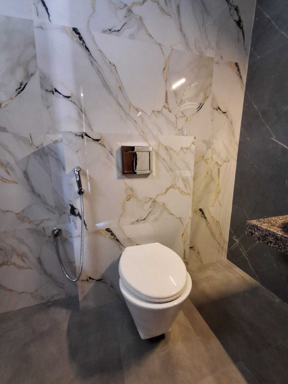 Kylpyhuone, jossa on marmoriseinä, wc ja suihkutila.