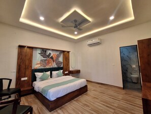 A modern bedroom with a wooden bed, a ceiling fan, and an air conditioning unit. - Orchard Hills Resorts (Pushkar)