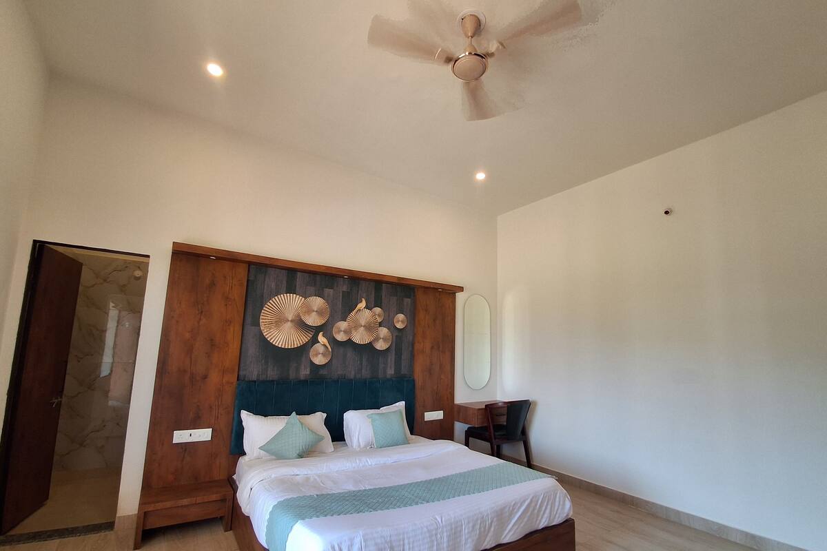 A spacious bedroom with a large bed, wooden headboard, and a ceiling fan.