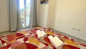 Ein Hotelzimmer mit einem großen, gesteppten Bett, einem Bild an der Wand und Blick aus dem Fenster.