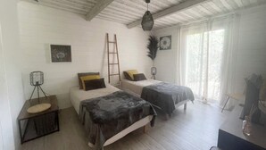 Een kamer met twee bedden, een ladder, een statief en een klein tafeltje.