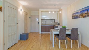 Una cocina moderna con armarios de madera y un comedor con mesa y sillas.