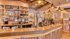 A bar area with shelves of liquor bottles, a cash register, and a wooden counter. - Premier Inn Blackpool - North Pier (Blackpool)