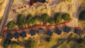 An aerial view of a solar farm with rows of solar panels and a few small buildings. - AV366 (Arenas Verdes)