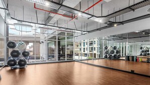 Ein Fitnessraum mit Übungsbällen, Holzboden und großen Fenstern.