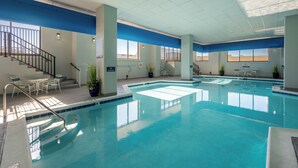 Une piscine intérieure dotée de plusieurs couloirs de nage, d’un escalier et d’espaces pour s’asseoir.