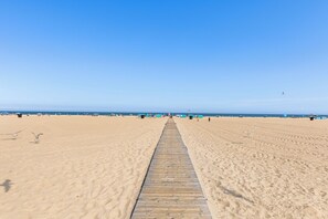 A beach with a wooden walkway leading to the sea, sandy beach, and clear blue sky. - Marigot Beach 907, Oceanfront condo with amazing views! (Ocean City)