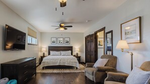A bedroom with a bed, a TV, a ceiling fan, and a large window. - Downtown | New Hot Tub! Walking Distance to Springs, Shops, Restaurants (Pagosa Springs)