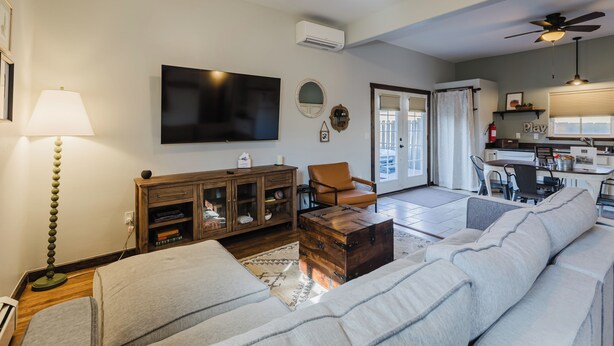 A living room with a sofa, a wooden cabinet, a television, and a ceiling fan. - Downtown | New Hot Tub! Walking Distance to Springs, Shops, Restaurants (Pagosa Springs)