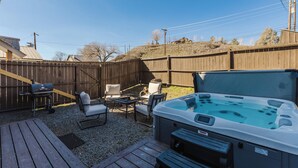 A backyard with a hot tub, outdoor furniture, and a wooden deck. - Downtown | New Hot Tub! Walking Distance to Springs, Shops, Restaurants (Pagosa Springs)