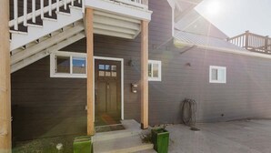 A residential building with a front porch, a staircase, and a garage door. - Downtown | New Hot Tub! Walking Distance to Springs, Shops, Restaurants (Pagosa Springs)