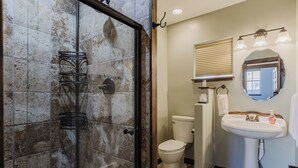 A bathroom with a shower, toilet, sink, and mirror. - Downtown | New Hot Tub! Walking Distance to Springs, Shops, Restaurants (Pagosa Springs)