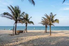 Een strand met palmbomen en een heldere lucht.