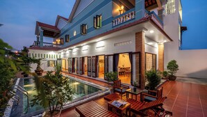 Un hôtel moderne doté d’une piscine, d’un espace extérieur aménagé et d’une entrée bien éclairée.