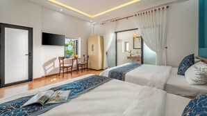 Une chambre d’hôtel avec deux lits, un bureau et une télévision.