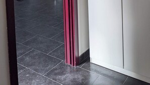 Una puerta que da a una cocina con un refrigerador, una mesa de comedor y una silla.