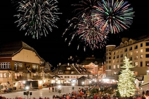 En byplads med mennesker, bygninger og et juletræ.