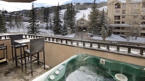 A hot tub on a balcony with a view of a ski resort and buildings. - Contemporary 3 Bedroom Ski In, Ski Out Condo in the Heart of Beaver Creek Village (Avon)