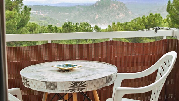 A balcony with a round table and chairs, overlooking a mountainous landscape. - Serene Lakeview Retreat (San Martín de Valdeiglesias)